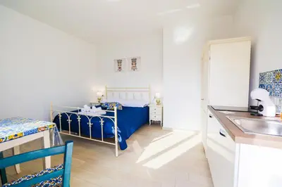 a small bedroom with a blue bed and a sink at Cà del Re Holiday in Partinico