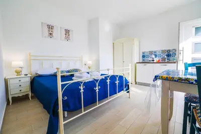 a bedroom with a bed with a blue comforter at Cà del Re Holiday in Partinico