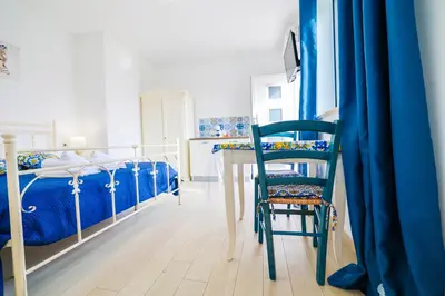 a room with two bunk beds and a chair at Cà del Re Holiday in Partinico