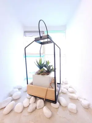 a lantern with a plant in it sitting on a table at JEY STUDIO_INDEPENDENT SEAFRONT APARTMENT in Terrasini