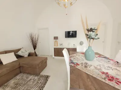 a living room with a couch and a table with a vase at JEY STUDIO_INDEPENDENT SEAFRONT APARTMENT in Terrasini