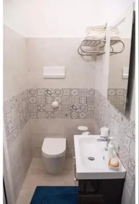 a bathroom with a white toilet and a sink at Posidonia in Porticello