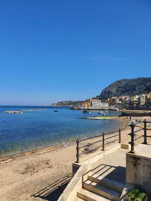 a beach with a fence next to the water at Terra D'Aspra in Bagheria