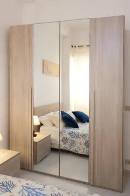 a bedroom with a mirrored closet and a bed at Confortevole appartamentino in Castellammare del Golfo