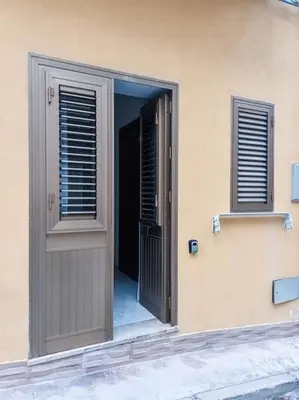 an open door of a building with two windows at Confortevole appartamentino in Castellammare del Golfo