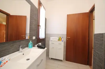 a bathroom with a sink and a mirror at CASA IL LIMONE 300M MARE PARK e GIARDINO PRIV WIFI in San Vito lo Capo