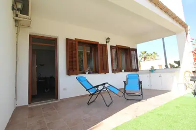 two blue chairs sitting on the patio of a house at CASA IL LIMONE 300M MARE PARK e GIARDINO PRIV WIFI in San Vito lo Capo