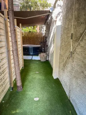 a small backyard with a tub and green grass at Tiski Toski Apartments Palermo in Palermo