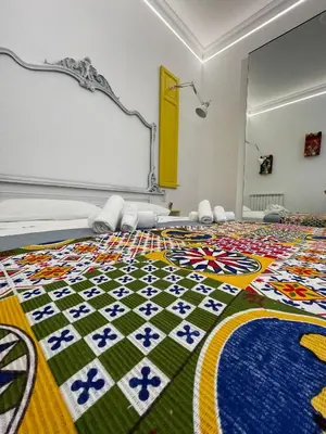 a bedroom with a colorful quilt on the floor at Tiski Toski Apartments Palermo in Palermo