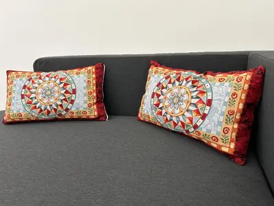 two pillows are sitting on a gray couch at Tiski Toski Apartments Palermo in Palermo