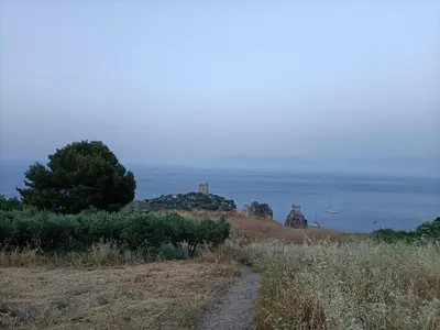 a dirt road on a hill next to the ocean at La casetta a Scopello in Scopello