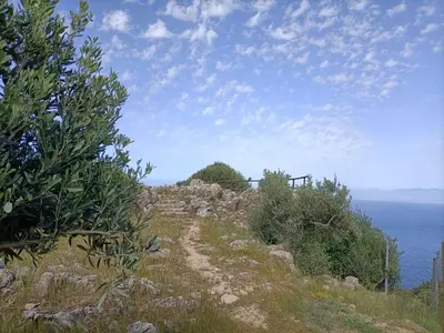 a dirt road on a hill near the ocean at La casetta a Scopello in Scopello