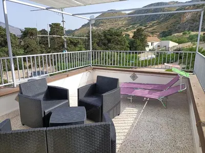 a balcony with chairs and a table at La casetta a Scopello in Scopello