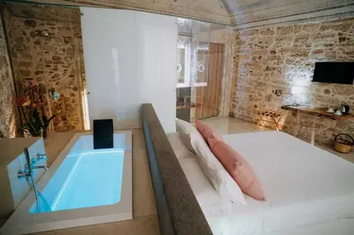 a room with a tub and a bed and a television at Ambrosia-Timeless Hosting in Palermo