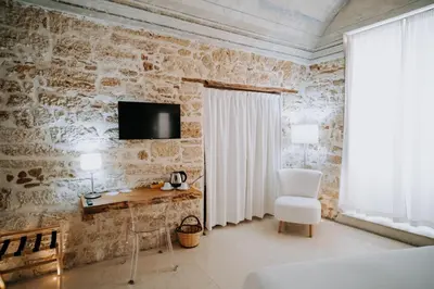 a room with a desk and a tv on a stone wall at Ambrosia-Timeless Hosting in Palermo