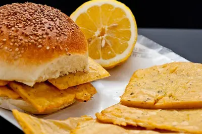 a sandwich and a lemon slice on a plate at IGIEA ROOMS in Palermo