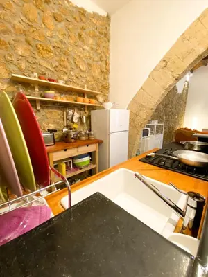 a kitchen with a sink and a stone wall at Scopello Home in Castellammare del Golfo