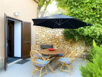 a wooden table with chairs and an umbrella at Scopello Home in Castellammare del Golfo