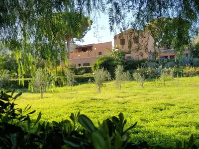a field with a building in the background at Scopello Home in Castellammare del Golfo