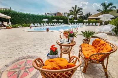 a table with food on it next to a pool at Villa in recidence a 100 metri dal mare con servizio di piscina a 100 metri vicino Cefalu in Campofelice di Roccella