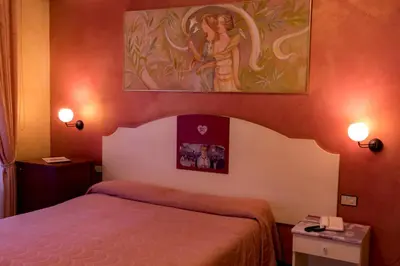 a bedroom with a bed and a painting on the wall at Hotel Joli in Palermo