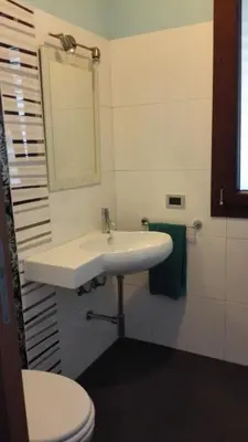 a bathroom with a white sink and a toilet at Villetta Isola in Isola delle Femmine