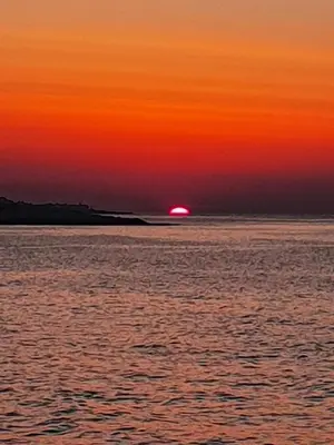 a sunset over the ocean with a cloudy sky at CASETTA PONENTE in Isola delle Femmine