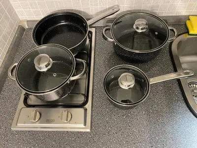 three pots and pans on a stove in a kitchen at Appartamento Ashur Mondello in Palermo