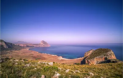 a view of a beach with the ocean and mountains at Pietro 4 in San Vito lo Capo