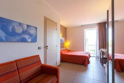 a hotel room with two beds and a couch at Hotel Villa d'Amato in Palermo