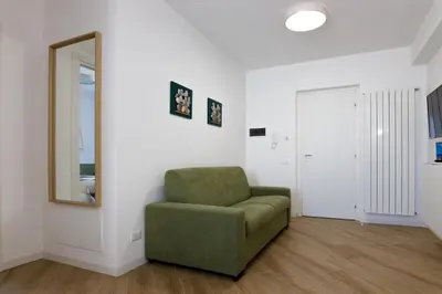 a living room with a green chair and a mirror at TERRAVERA in Terrasini