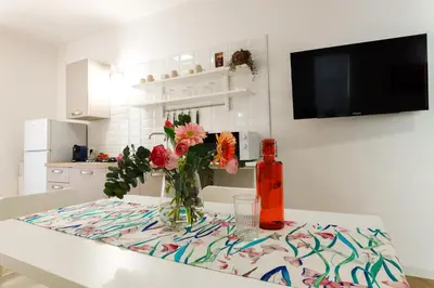 a table with a vase of flowers and a bottle on it at TERRAVERA in Terrasini
