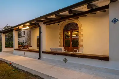 a house with a porch with two chairs on it at Scialari Country House in Castellammare del Golfo