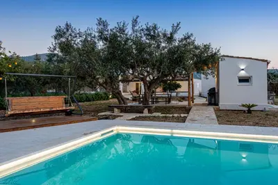 a swimming pool in a yard with a bench and trees at Scialari Country House in Castellammare del Golfo