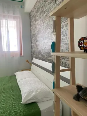 a small bedroom with a bunk bed and a ladder at La Casetta Blu al Mulino in San Vito lo Capo