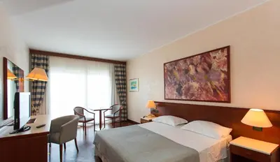 a hotel room with a bed and a desk at Splendid Hotel La Torre in Mondello