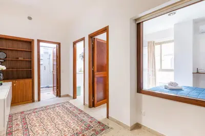 a living room with a window and a bedroom at GuestHost - Teatro Politeama and Teatro Massimo Cozy Apartment in Palermo