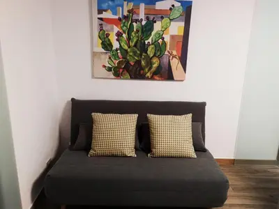 a bed with two pillows and a painting on the wall at Casa dei Tre Re in Palermo