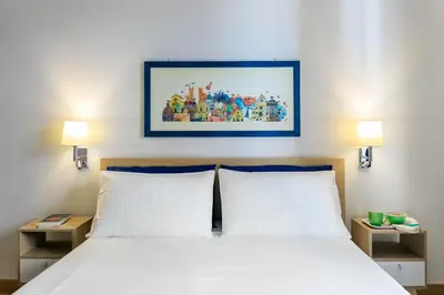 a bed with two white pillows and a picture on the wall at Kalbita home in Palermo