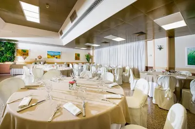 a banquet hall with white tables and white chairs at Astoria Palace Hotel in Palermo