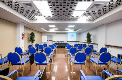 a conference room with blue chairs and a table at Astoria Palace Hotel in Palermo