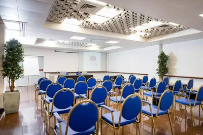 a conference room with blue chairs and a podium at Astoria Palace Hotel in Palermo
