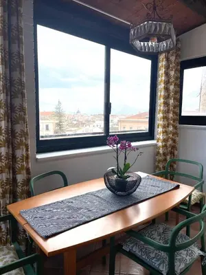 a table with a vase on it in a room with windows at Loft Aragonese in Palermo