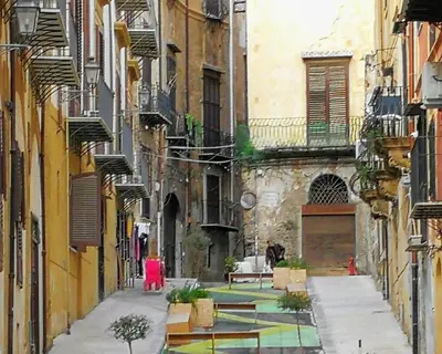 an alley between two buildings with a person in a red dress at atocà2 confortevole loft- vedi anche atocà1 in Palermo