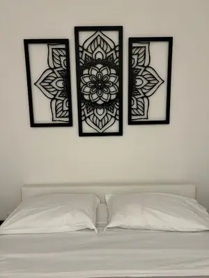 four framed pictures on a wall above a bed at Lux Apartment in Historical Center of Palermo in Palermo