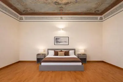 a bedroom with a bed and two tables with lamps at Open Sicily Residence - Central Apartments Near Quattro Canti in Palermo