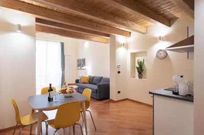 a kitchen and a living room with a table and chairs at Open Sicily Residence - Central Apartments Near Quattro Canti in Palermo