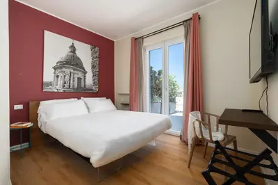 a bedroom with a large white bed and a window at Suite al centro di Palermo con terrazza privata in Palermo