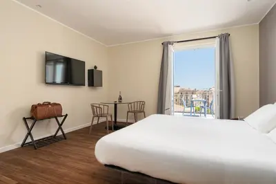 a hotel room with a bed and a table with chairs at Suite al centro di Palermo con terrazza privata in Palermo