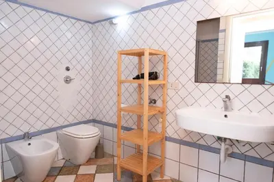 a bathroom with a toilet and a sink at Villa Morici con ampio giardino in San Vito lo Capo